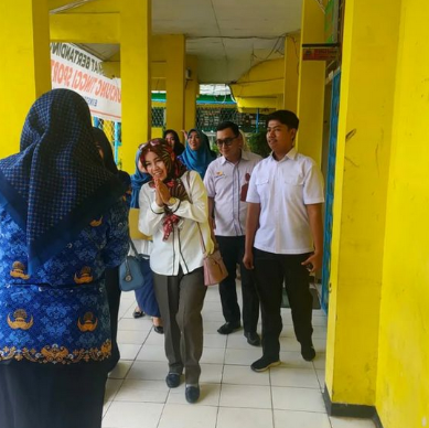 Photo 4: Teacher helping student with math problems on a whiteboard in a modern classroom